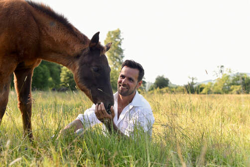 Aaron Janicki sharing a quiet moment with a horse in the pasture